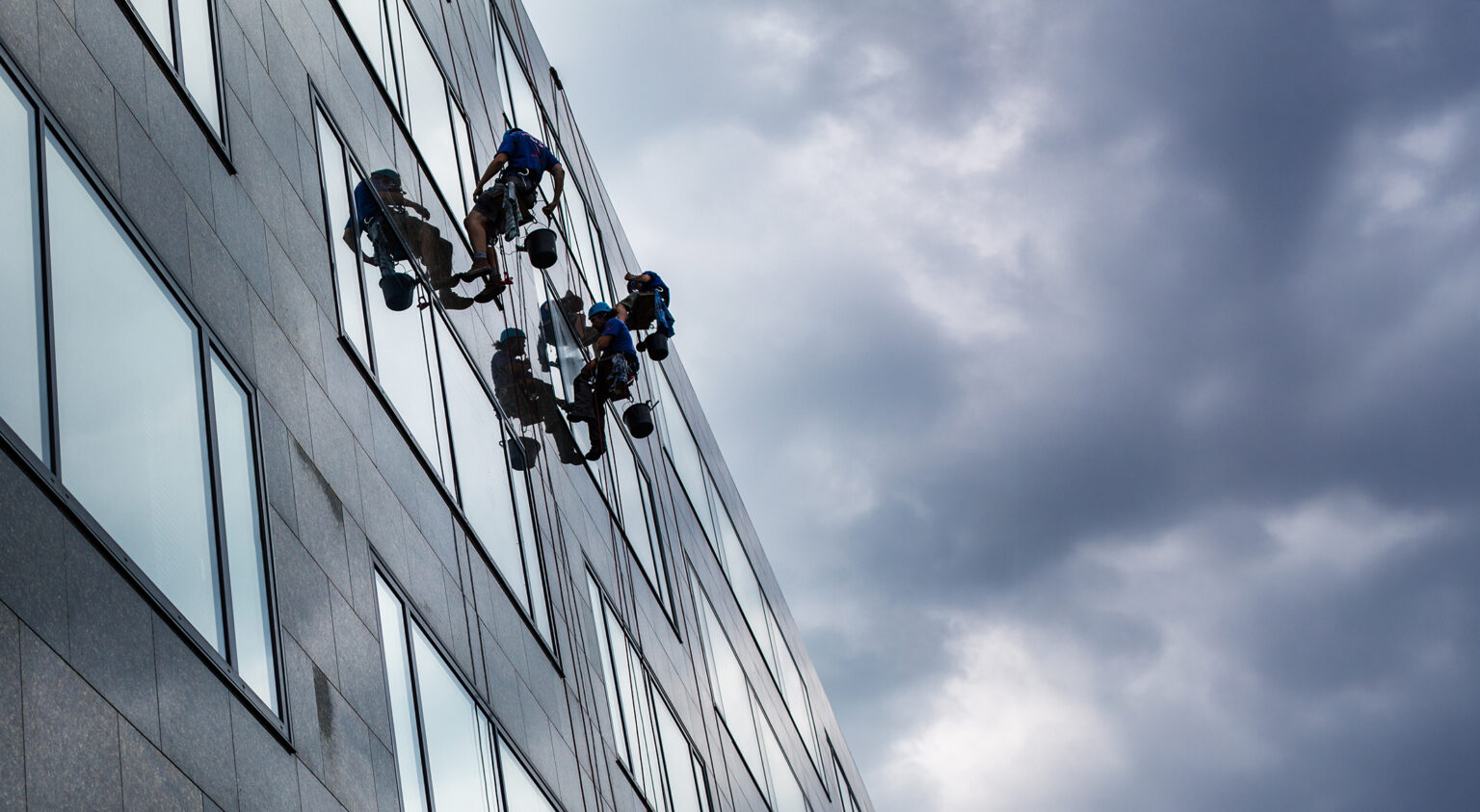 Climbers washing windows of a modern high-rise building