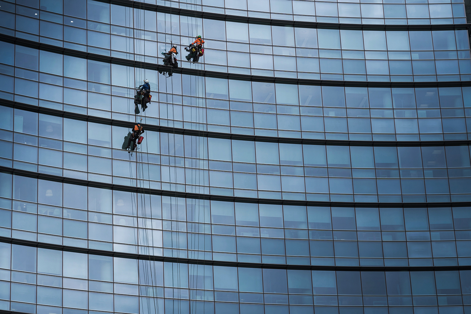 Window washers cleaning the glass facade of a skyscraper