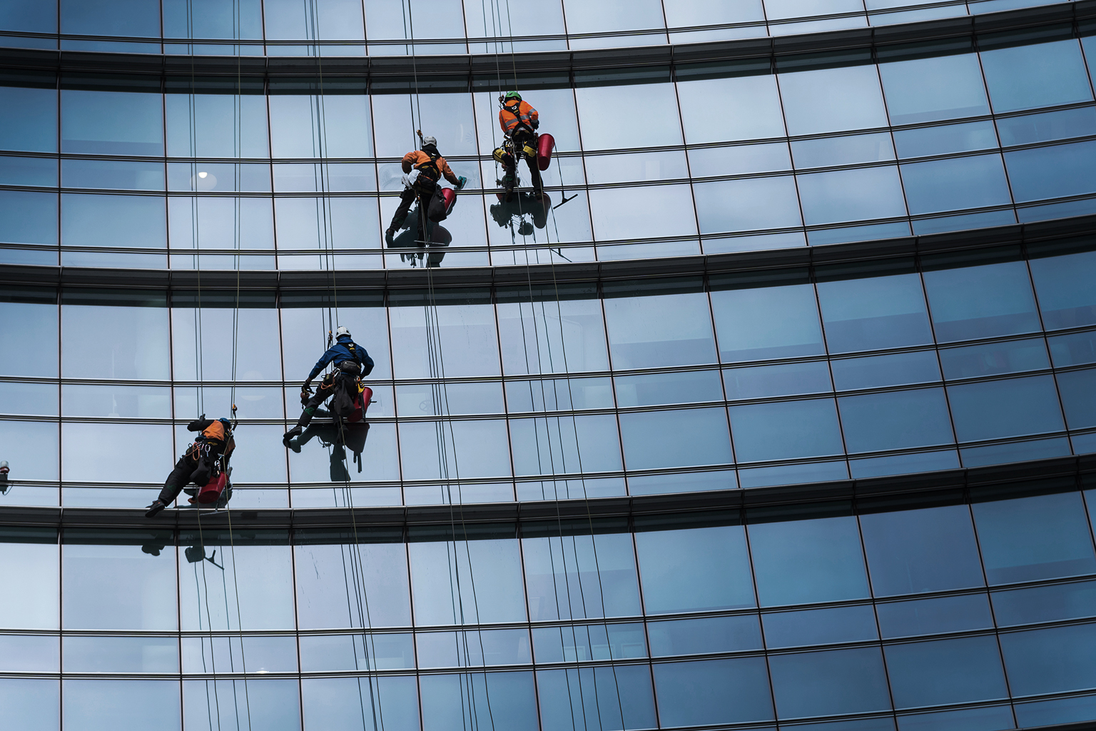 Window washers cleaning the glass facade of a skyscraper